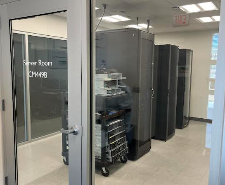 A room with computer servers inside. A glass door on the outside reads, "Server Room."
