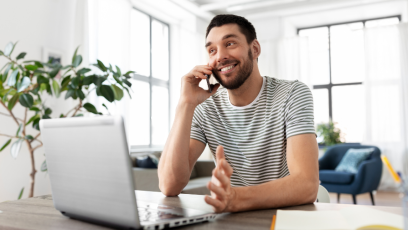 Man on phone call while working on laptop