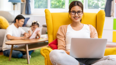 Young female professional on laptop at home with family