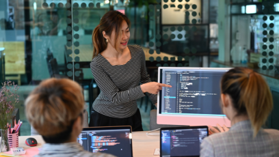 Three professionals work with artificial intelligence on their computer screens.
