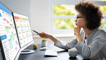 A woman sits in front of her computer contemplating her online calendar and her tasks list.