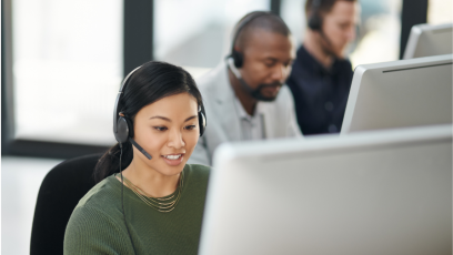 Women working on laptop while providing customer service over headset
