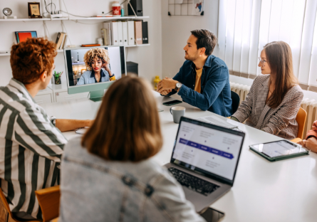 Co-workers collaborating in a meeting which is virtual and in-person.