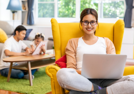 Young female professional on laptop at home with family