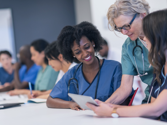 Medical Administrative Assistant talking with office employees