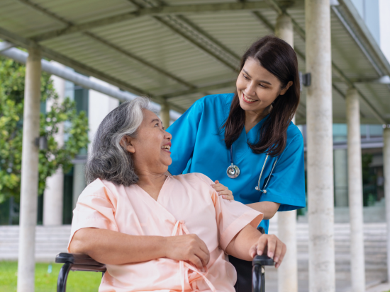 Patient Care Tech assisting a patient in a chair