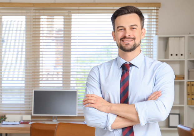 Man with shirt and tie smiling in an office setting