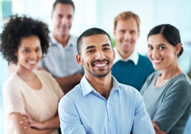 Group of 5 smiling professionals with young man in the front
