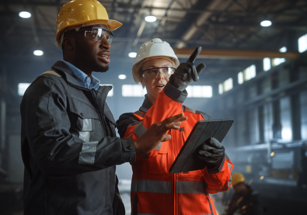 Two manufacturing workers in full safety gear