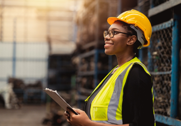 Woman in manufacturing in hard hat and safety vest