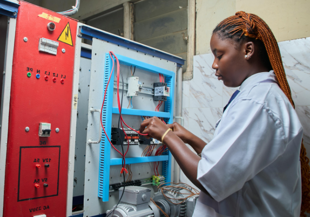 Female electrical technician working on piece of equipment
